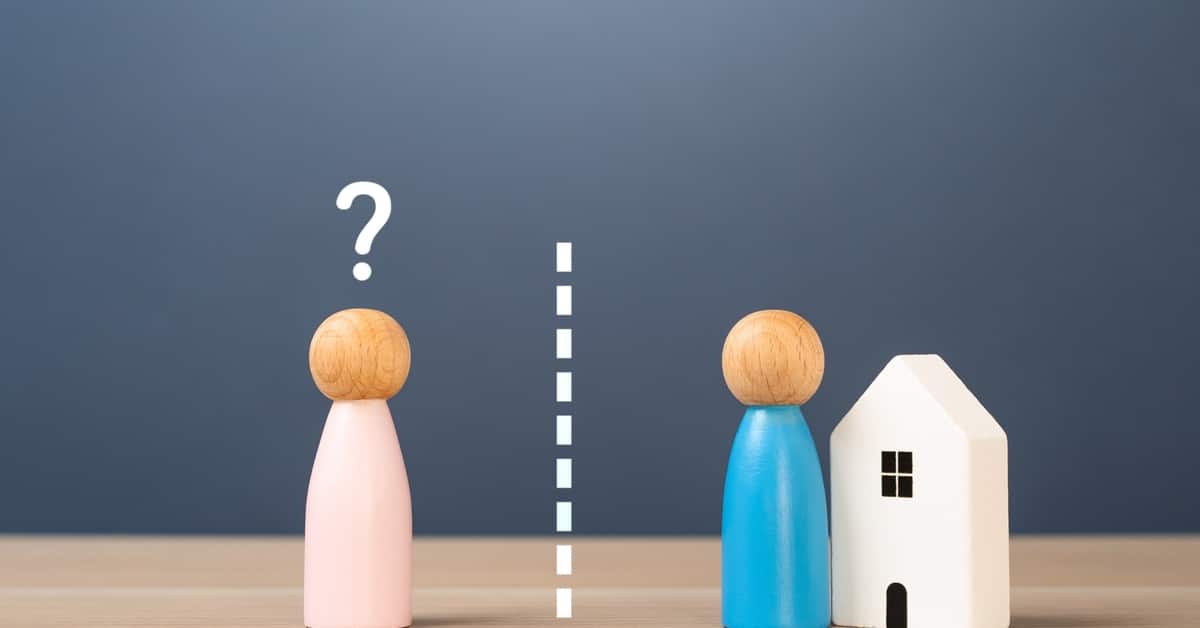 A pink wooden figure with a question mark above its head is separated from a blue figure and a small white house by a dashed line.